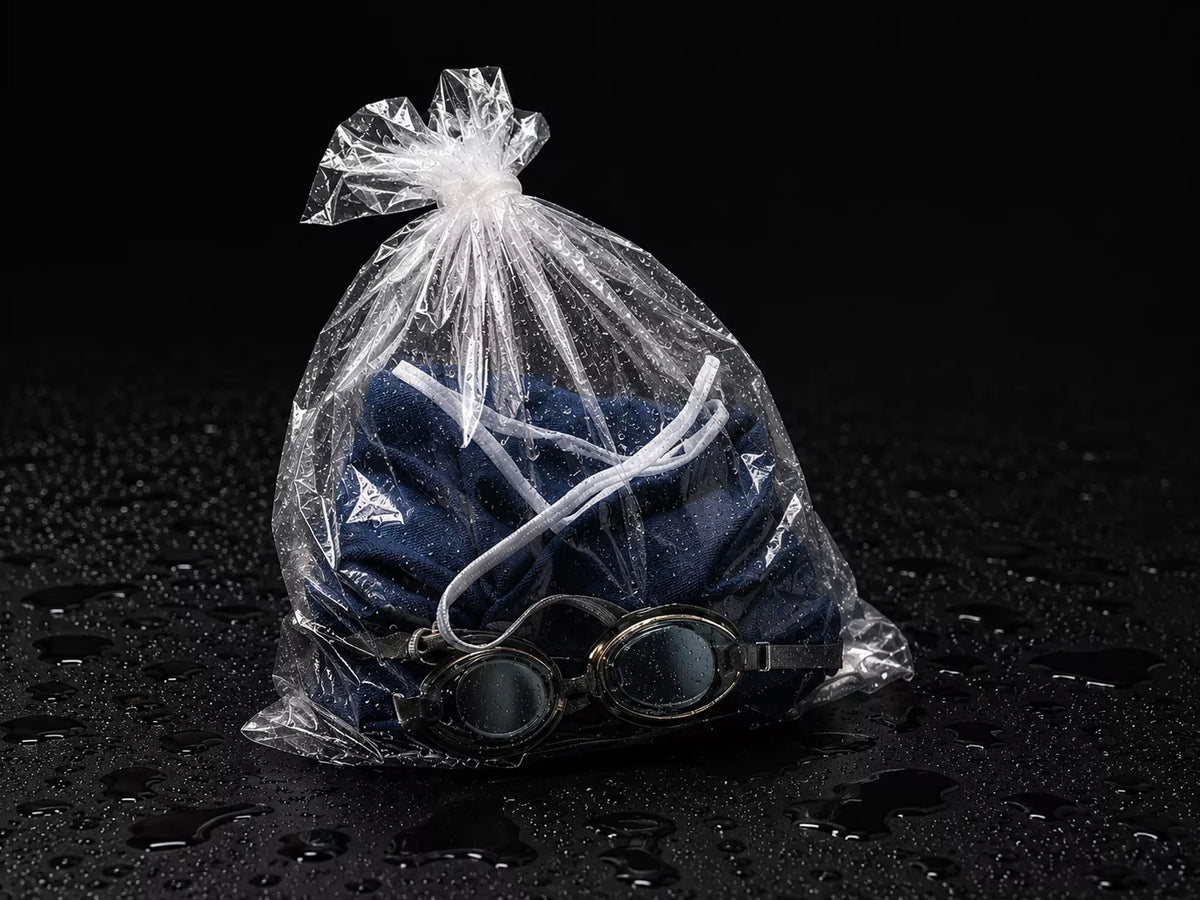 Wet swimsuit and pool gear stored in a plastic bag — leaking and torn